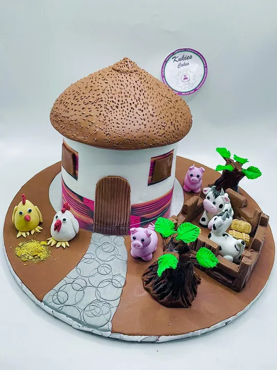 African rondavel hut shaped novelty cake with a thatch roof and fondant farm animals