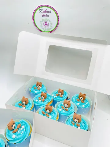 Box of blue buttercream cupcakes topped with fondant teddy bears for a baby boy