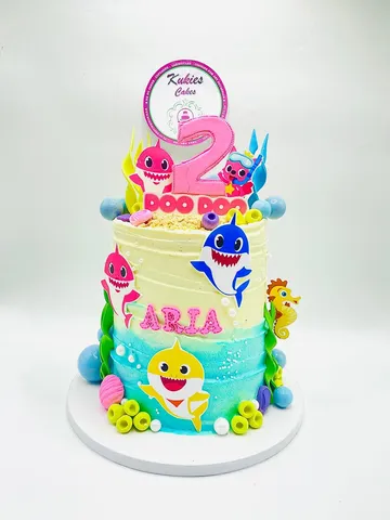 Pastel Baby Shark themed two-tier cake with ocean decorations