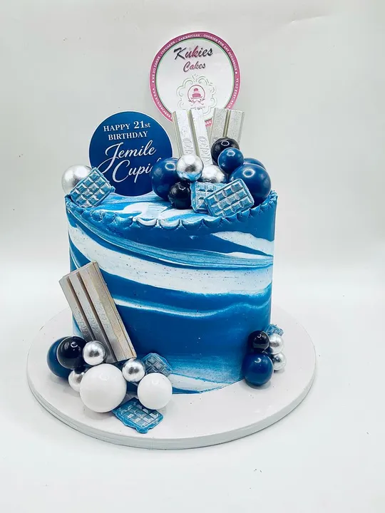 Blue and white marble cake with silver and blue spheres for a 21st birthday