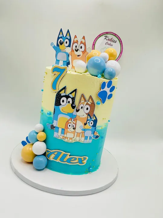 Yellow and teal Bluey themed birthday cake with a printed family design