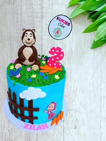 Blue cartoon bear themed cake with a fondant fence and number 2 topper