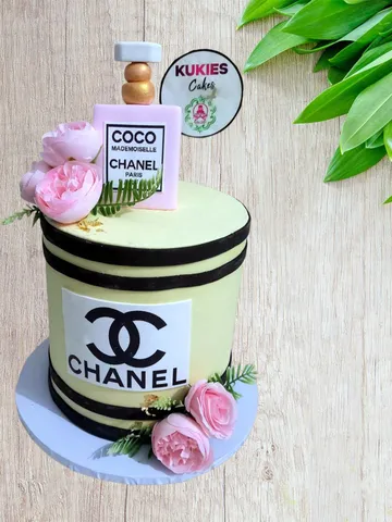 Pale yellow cake styled as a Chanel perfume box with a fondant bottle topper
