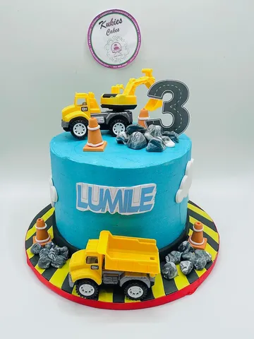 Blue construction truck themed cake with toy trucks and cones