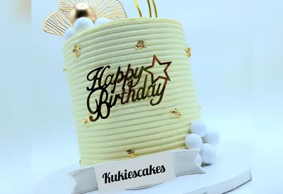 Cream ribbed cake with gold leaf flecks and a gold fan decoration