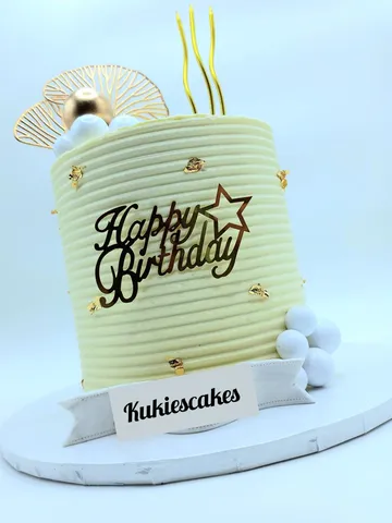 Cream ribbed cake with gold leaf flecks and a gold fan decoration