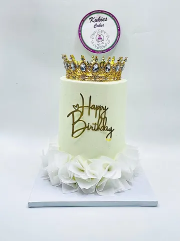 Pale cream cake with a bejewelled gold crown topper and ruffled petal base