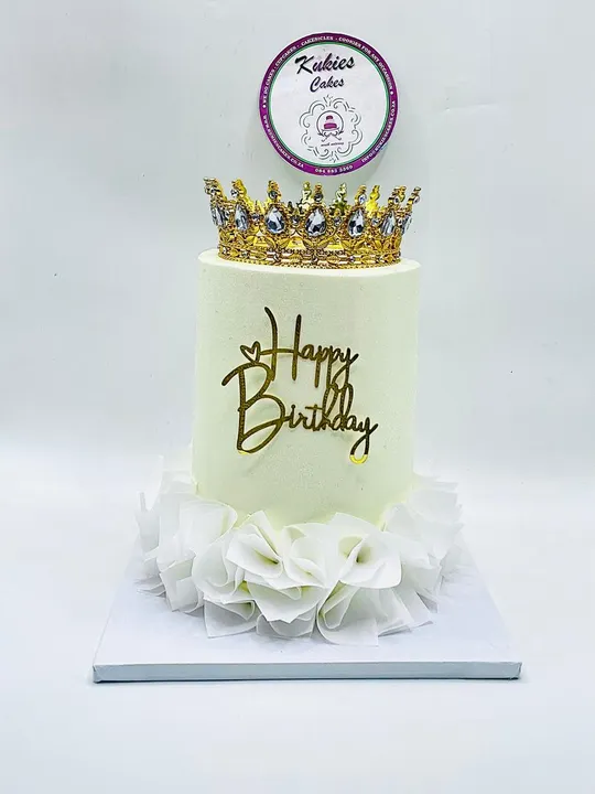 Pale cream cake with a bejewelled gold crown topper and ruffled petal base