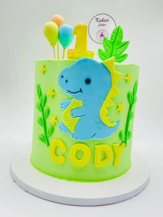 Green cartoon dinosaur themed first birthday cake