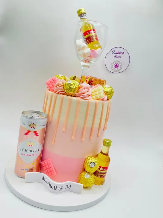 Peach drip cake with mini bottles and chocolates for a 22nd birthday
