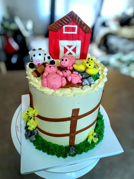 Farm themed kids birthday cake with a red barn and fondant farm animals