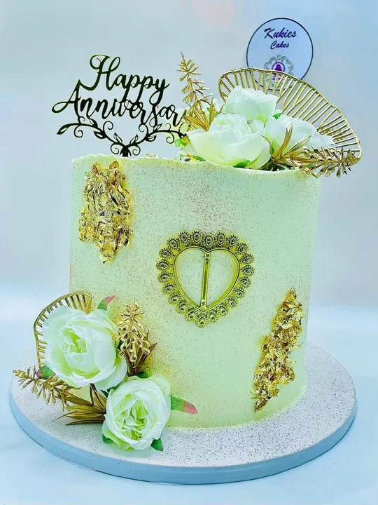 Cream anniversary cake with white roses and gold leaf detailing