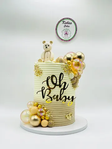 Cream and gold Oh Baby baby shower cake with a fondant teddy bear and gold leaf