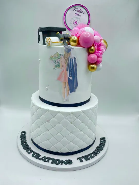 White two-tier graduation cake with a mortarboard topper and graduate illustration