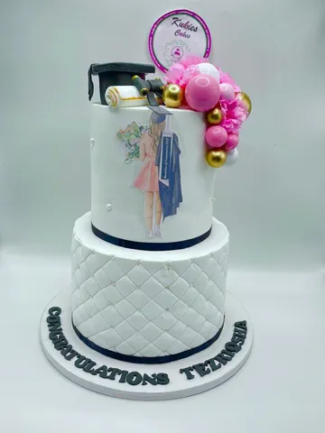 White two-tier graduation cake with a mortarboard topper and graduate illustration