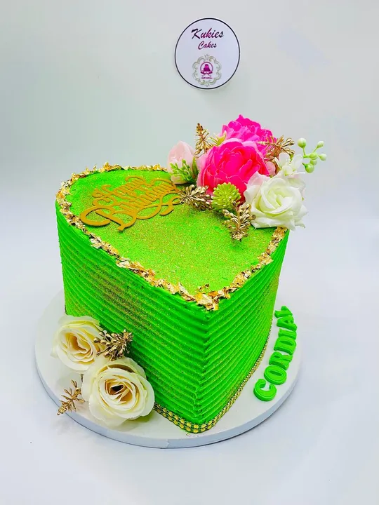 Bright green heart shaped cake with pink and white flowers