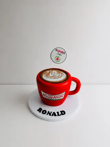 3D coffee cup shaped novelty cake styled as a Krispy Kreme cup