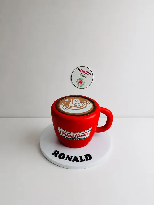 3D coffee cup shaped novelty cake styled as a Krispy Kreme cup