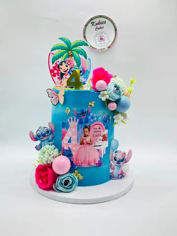 Blue tiered Lilo and Stitch themed cake with tropical flowers and a photo topper