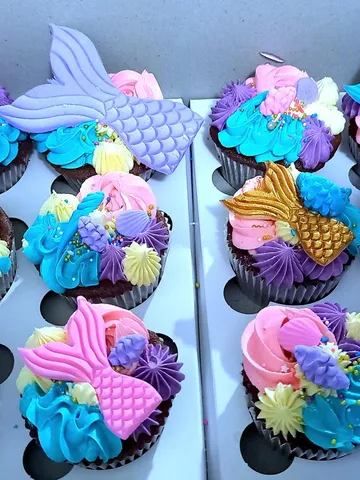 Cupcakes with fondant mermaid tails, starfish and shells over teal and purple buttercream