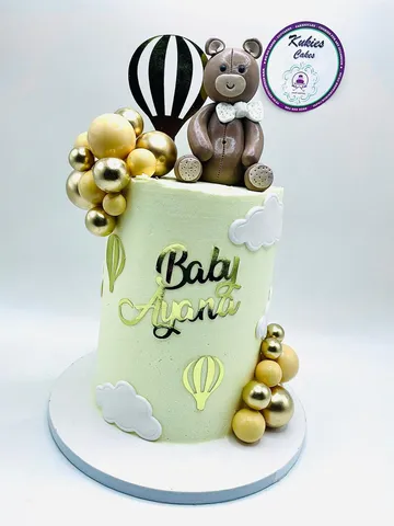 Pale mint baby shower cake with a gold hot air balloon topper