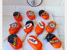 Orange cakesicles with Nerf branded toppers and target designs