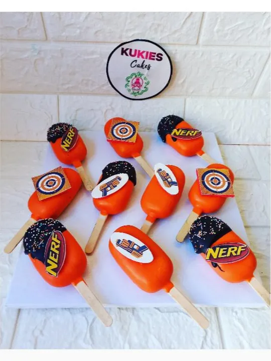 Orange cakesicles with Nerf branded toppers and target designs