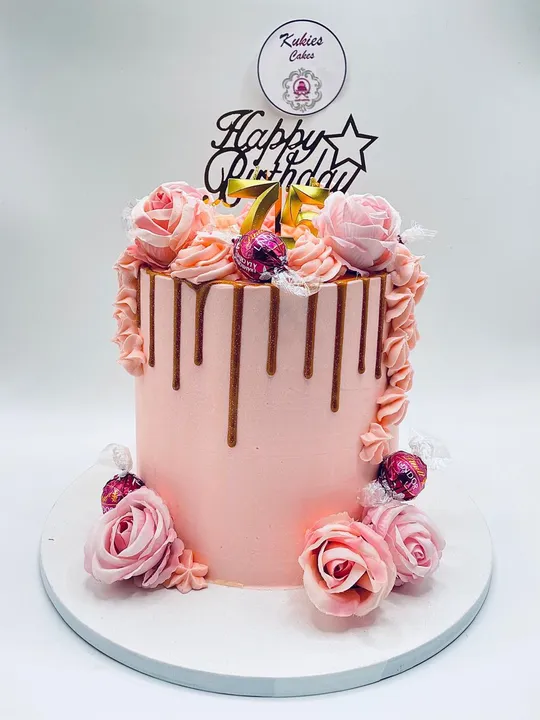 Pink drip cake with roses and a gold 75 topper