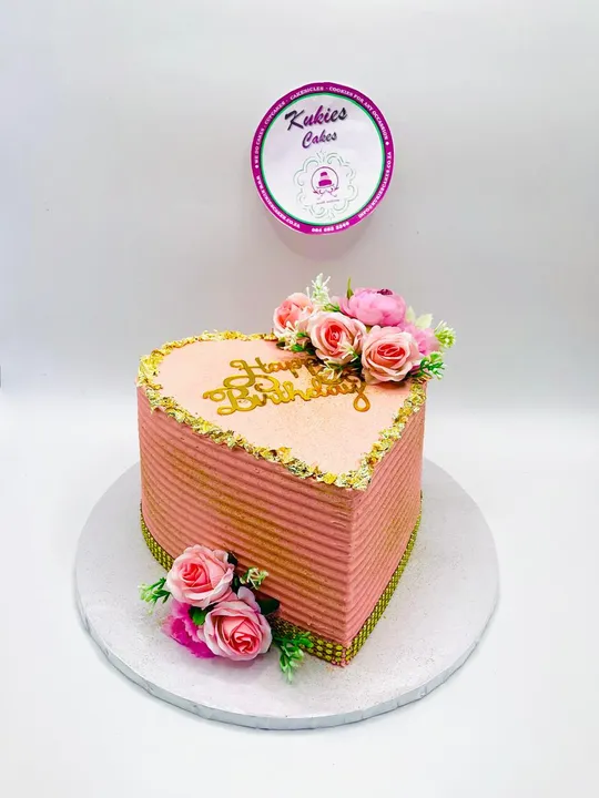 Pink heart shaped cake with pink roses and gold leaf trim