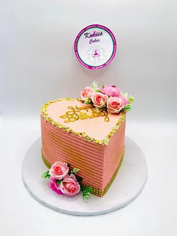 Pink heart shaped cake with pink roses and gold leaf trim