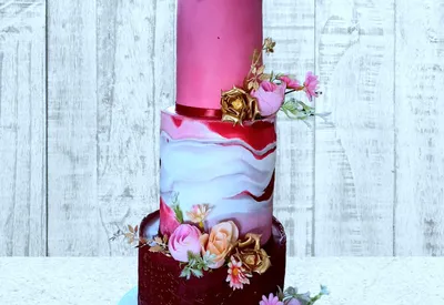 3-tier pink and red marble wedding cake with gold flowers