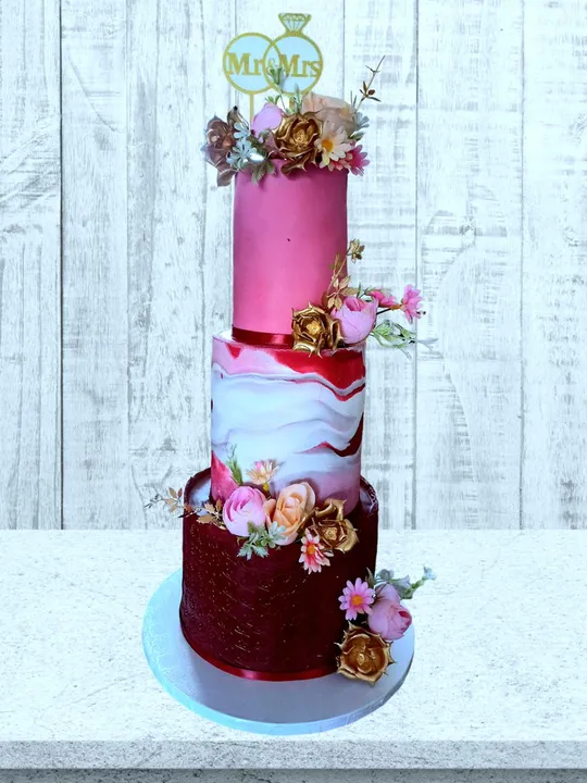 3-tier pink and red marble wedding cake with gold flowers