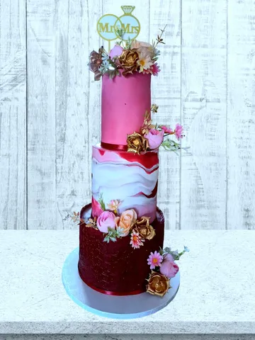 3-tier pink and red marble wedding cake with gold flowers