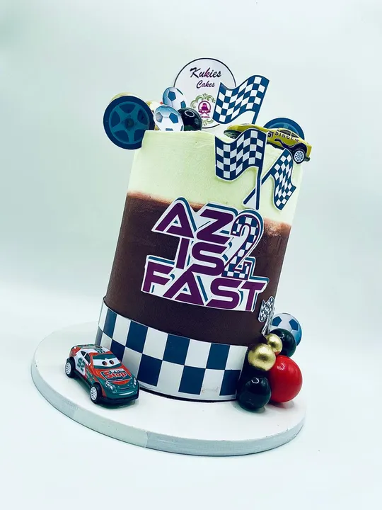 Mint and brown racing themed cake with toy race cars for a 2nd birthday