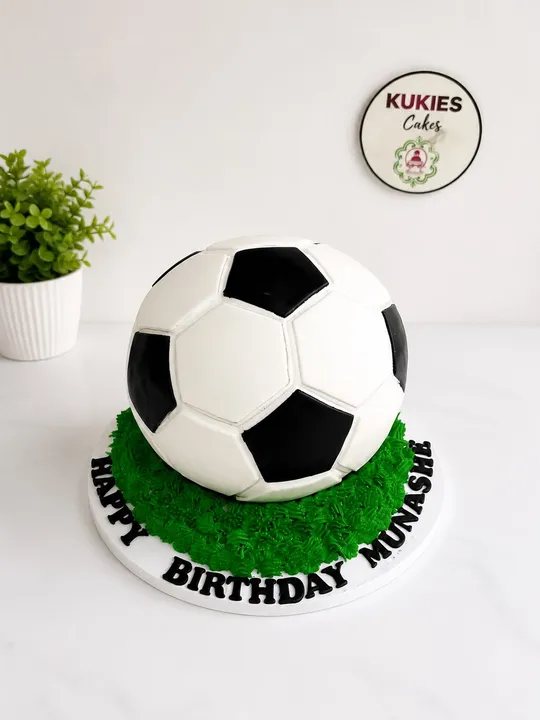 3D soccer ball shaped cake on green buttercream grass