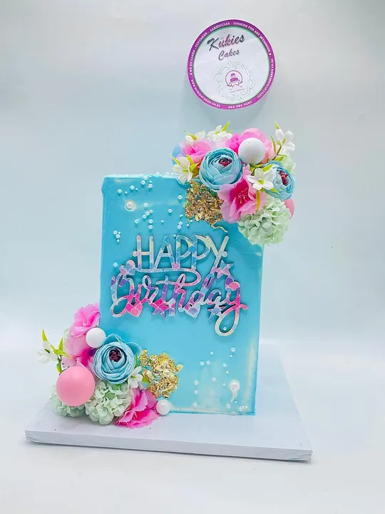 Teal sheet cake with floral corners and a holographic Happy Birthday topper