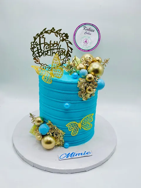 Teal cake with gold glitter butterflies and gold and blue baubles