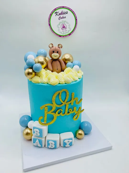 Teal Oh Baby cake with a fondant teddy bear and alphabet blocks