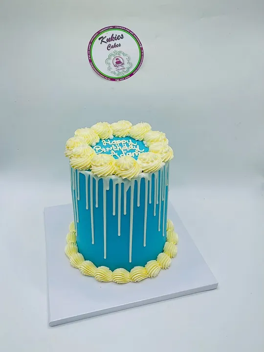 Teal blue drip cake with yellow buttercream swirls
