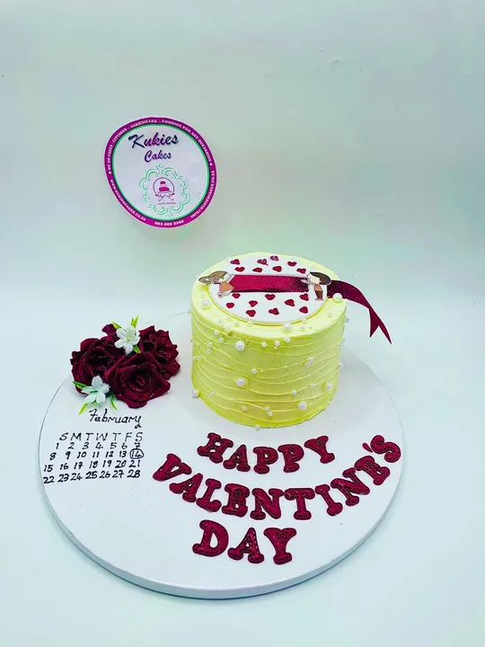 Pale yellow Valentine's Day cake with red roses and a calendar plaque