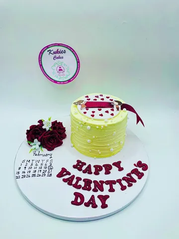 Pale yellow Valentine's Day cake with red roses and a calendar plaque