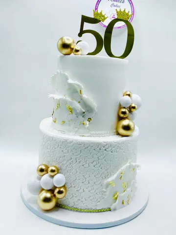 White two-tier marble effect cake with gold leaf and a gold 50 topper