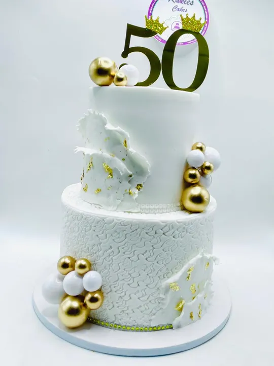 White two-tier marble effect cake with gold leaf and a gold 50 topper